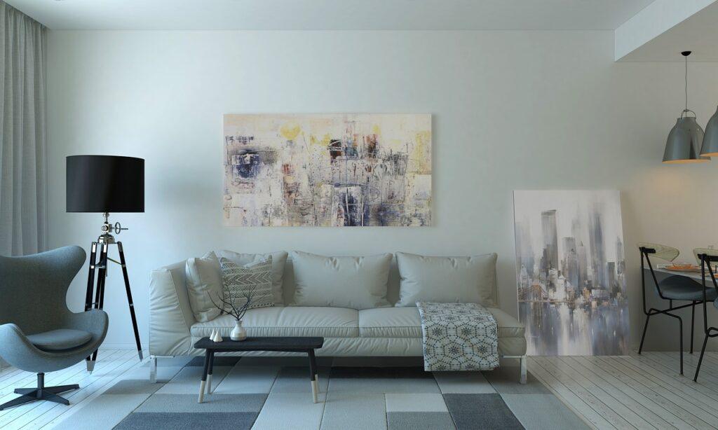 Staged small living room with neutral sofa and plants