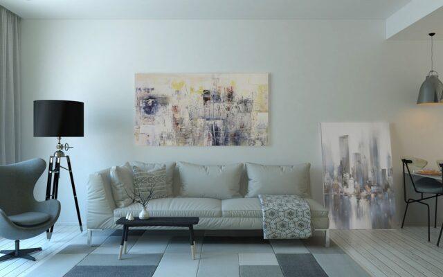Staged small living room with neutral sofa and plants